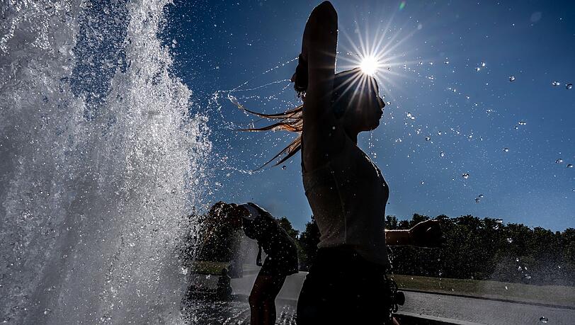 Temperaturen von annähernd 40 Grad in der Hauptstadt - diese Touristen nutzen einen Brunnen zur Abkühlung.