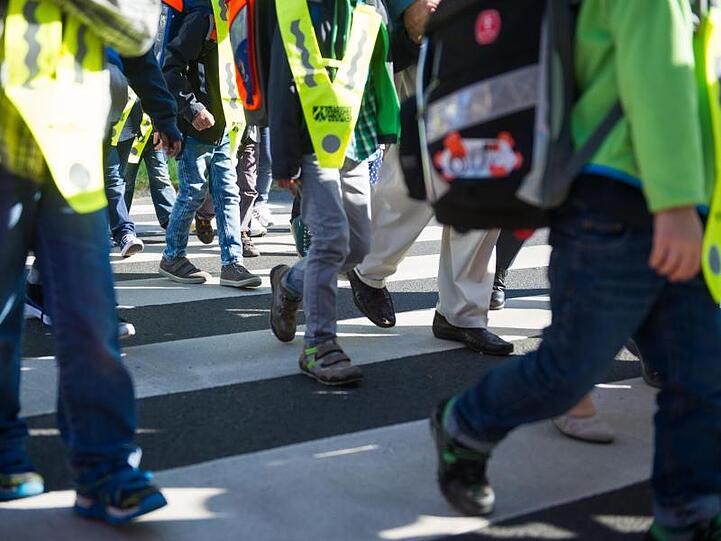 Erstklässler überqueren einen Zebrastreifen. Foto: Matthias Balk/Archiv