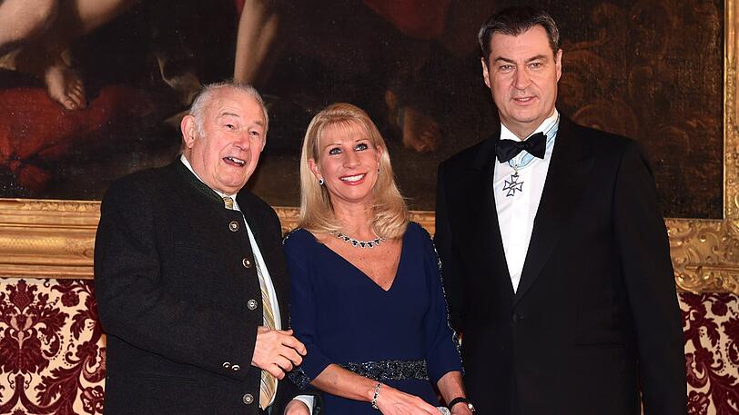Markus Söder (CSU), Ministerpräsident (r) und seine Frau Karin Baumüller-Söder (m) stehen zusammen mit Günther Beckstein (CSU), ehemaliger bayerischer Ministerpräsident (l) beim Defilee des Neujahrsempfang in der Münchner Residenz.