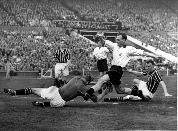 Beim englischen Pokalfinalspiel im Wembley Stadion in London zwischen Manchester City und Birmingham City: Links am Boden der deutsche Torhüter von Manchester City, Bert Trautmann.