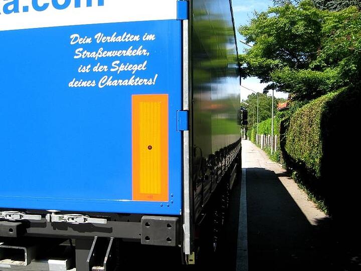 "Dein Verhalten im Straßenverkehr ist der Spiegel deines Charakters!", steht auf dem Lkw, der diesen Radlweg in Solln zuparkt.