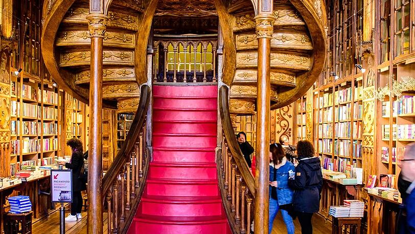 Die Livraria Lello in Porto zählt zu den schönsten Buchhandlungen der Welt - mit kunstvollen Holzdetails und geschwungener Treppe erinnert sie an Hogwarts voller Bücher. Die Livraria Lello in Porto zählt zu den schönsten Buchhandlungen der Welt - mit kunstvollen Holzdetails und geschwungener Treppe erinnert sie an Hogwarts voller Bücher.
