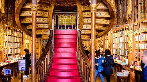 Die Livraria Lello in Porto z&auml;hlt zu den sch&ouml;nsten Buchhandlungen der Welt - mit kunstvollen Holzdetails und geschwungener Treppe erinnert sie an Hogwarts voller B&uuml;cher.