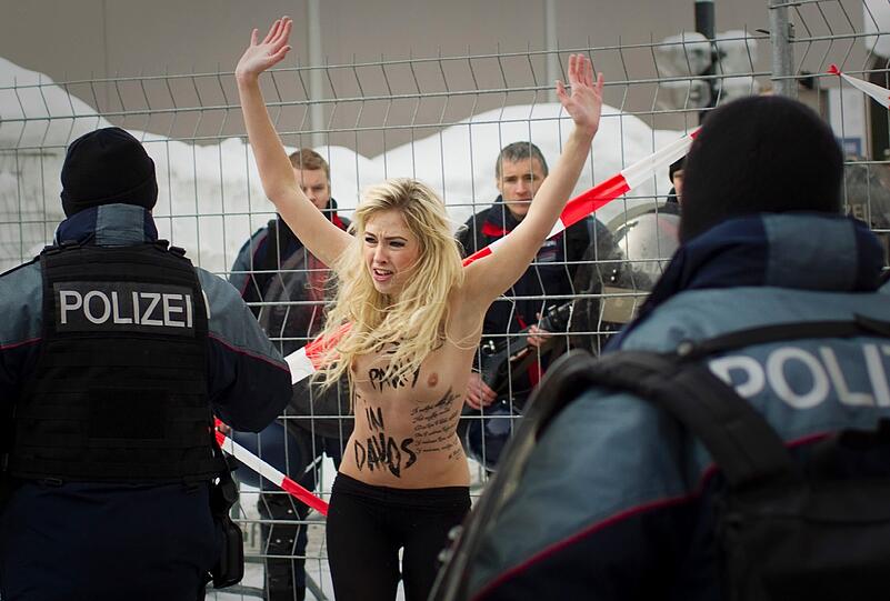 Nacktprotest in Davos: Ukrainerinnen demonstrieren barbusig am Zaun vor dem Weltwirtschaftsforum. Die Polizei greift ein - die Bilder.