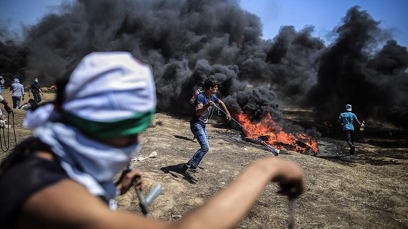 Ein Palästinenser schleudert Steine auf die israelische Armee bei Auseinandersetzungen an der Grenze zu Israel.