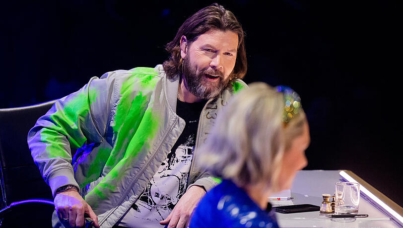 Rea Garvey am Ratepult der Prosieben-Show "The Masked Singer". Vorne Ruth Moschner.