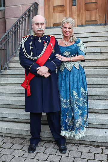 Bayerns Ministerpräsident Markus Söder (CSU, l) und Karin Baumüller-Söder gehen als Reichskanzler Otto von Bismarck und eine Dame aus der Zeit Bismarcks zum Franken-Fasching und stehen für ein Foto auf einer Treppe am Staatstheater Nürnberg.
