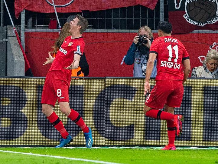 Leverkusens Torschütze Lars Bender (l-r) bejubelt sein Tor zum 4:3 mit Leverkusens Nadiem Amiri.