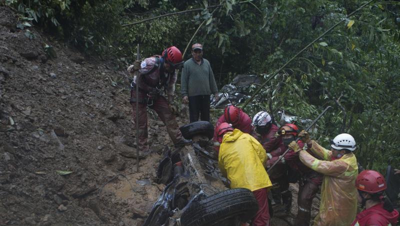 Feuerwehrleute versuchen nach einer Schlammlawine in Bolivien Opfer aus einem Auto zu retten. Feuerwehrleute versuchen nach einer Schlammlawine in Bolivien Opfer aus einem Auto zu retten.