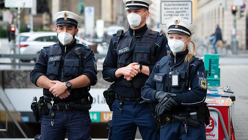 Bundespolizisten stehen in München mit Maske vor einem U-Bahneingang. Nicht jeder von ihnen ist mit einem eigenen Diensthandy ausgestattet.