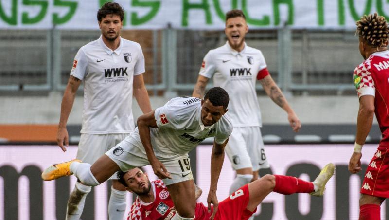 Augsburgs Felix Uduokhai (v) und der Mainzer Danny Latza kämpfen um den Ball.