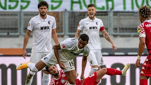 Augsburgs Felix Uduokhai (v) und der Mainzer Danny Latza kämpfen um den Ball.