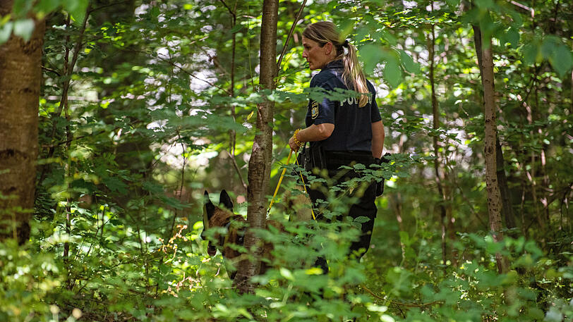 Die Polizei sucht ein Waldstück in der Nähe des Tatorts ab.
