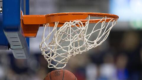 Ein Basketball fällt durch das Netz vom Basketballkorb. Foto: Lukas Schulze/dpa/Symbolbild