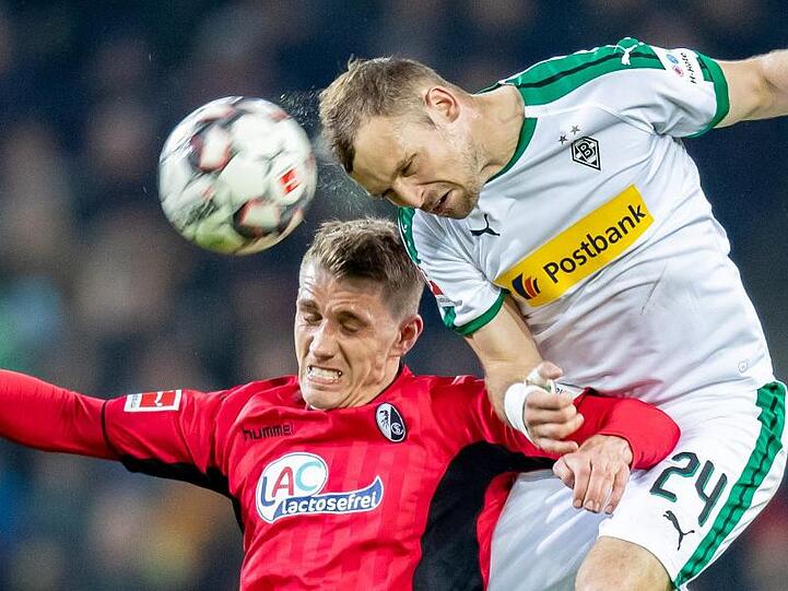 Freiburgs Nils Petersen (l) im Kopfballduell mit dem Gladbacher Tony Jantschke.