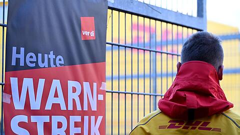 Ein warnstreikender DHL-Mitarbeiter an einem Standort der Post, die zu DHL geh&ouml;rt.