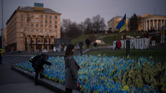 Eine Frau betrachtet ukrainische Flaggen, die zum Gedenken an die Gefallenen des Krieges in der Nähe des Maidan-Platzes im Zentrum von Kiew aufgestellt wurden.
