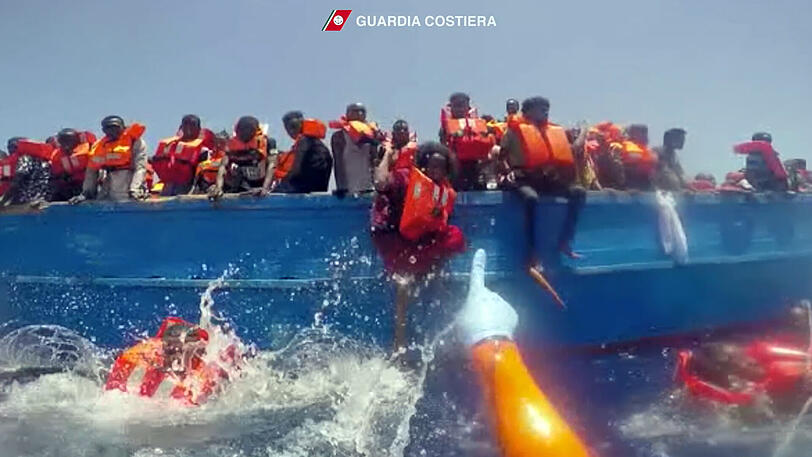 Die Szene aus einem Video der italienischen Küstenwache zeigt die Rettung von Flüchtlingen im Mittelmeer