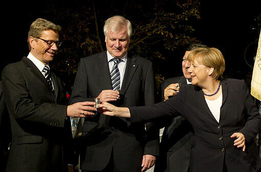 "Da war ja fast nichts mehr drin!" empört sich Außenminister Guido Westerwelle: Mit fast leerem Glas hatte Kanzlerin Angela Merkel mit ihm angestoßen - "auf die Koalition".