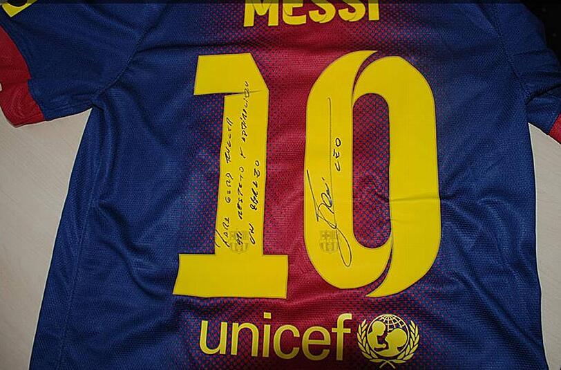 Lionel Messis Geschenk an den FC Bayern: Ein Messi-Trikot vom FC Barcelona mit handschriftlichen Grüßen an Gerd Müller.