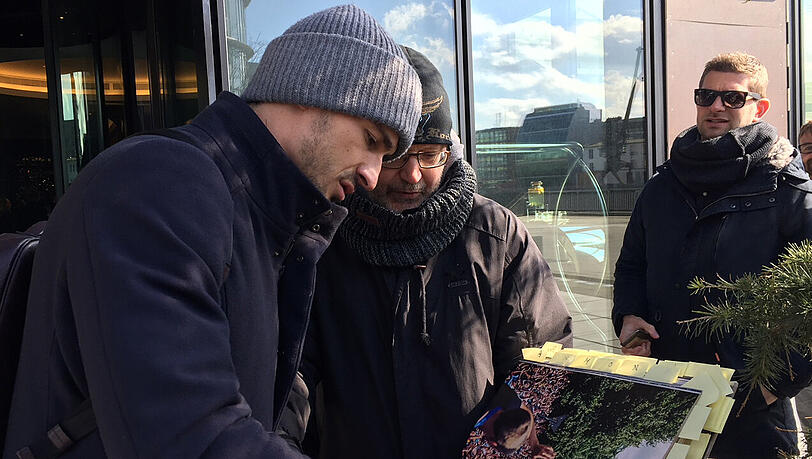 Mats Hummels (links) erfüllt vor dem Teamhotel der DFB-Elf Autogrammwünsche.