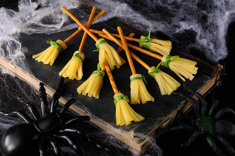 Hexenbesen aus Käse und Salzstangen sind ein lustiges Halloween-Fingerfood, besonders für Kinder. Schneiden Sie Gouda, Emmentaler oder veganen Käse in dünne Streifen von drei bis fünf Zentimetern Länge. Befestigen Sie sie mit einem Kräuterstängel wie etwa Schnittlauch oder Petersilie an einer Salzstange. So entstehen kleine essbare Hexenbesen. Hexenbesen aus Käse und Salzstangen sind ein lustiges Halloween-Fingerfood, besonders für Kinder. Schneiden Sie Gouda, Emmentaler oder veganen Käse in dünne Streifen von drei bis fünf Zentimetern Länge. Befestigen Sie sie mit einem Kräuterstängel wie etwa Schnittlauch oder Petersilie an einer Salzstange. So entstehen kleine essbare Hexenbesen.