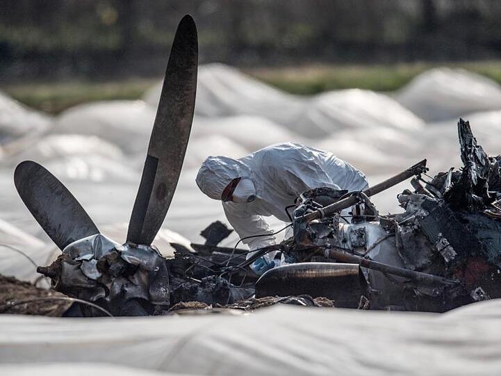 Ein Experte untersucht das ausgebrannte Flugzeugwrack.