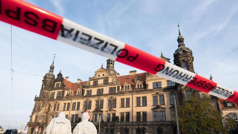 Zwei Mitarbeiter der Spurensicherung stehen vor dem Residenzschloss mit dem Grünen Gewölbe hinter einem Absperrband. Zwei Mitarbeiter der Spurensicherung stehen vor dem Residenzschloss mit dem Grünen Gewölbe hinter einem Absperrband.