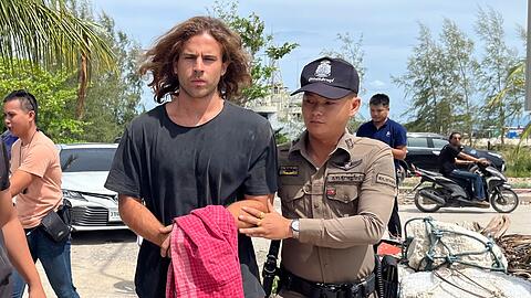 Ein thailändischer Polizist mit dem verdächtigen Spanier, der den Mord an dem Chirurgen gestanden hat.