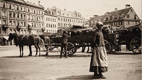 Ein Pferdewagen mit Brennholz für den Verkauf steht um 1890 am Isartorplatz. An der nahen Unteren Lände an der Isar lieferten Flöße die Stämme für die Bevölkerung an.