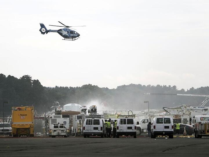 Ein Rettungshubschrauber fliegt über dem Absturzort des B-17-Bombers am Bradley International Airport. Bei dem Unglück sind mindestens 14 Menschen verletzt worden.
