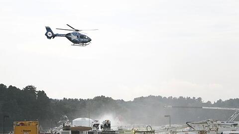 Ein Rettungshubschrauber fliegt über dem Absturzort des B-17-Bombers am Bradley International Airport. Bei dem Unglück sind mindestens 14 Menschen verletzt worden.