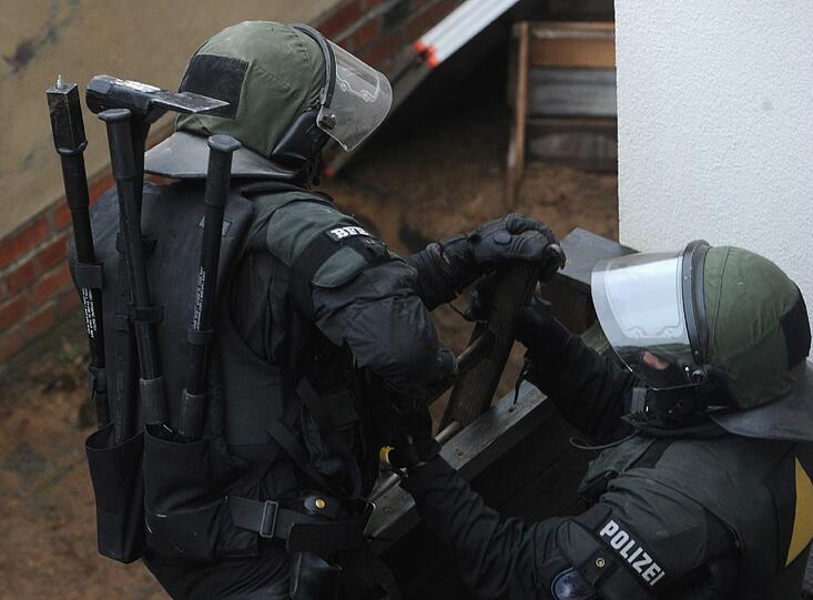 Die Besetzer werfen Konfetti, unten steht ein SEK-Kommando der Polizei: In Greifswald wurde ein besetztes Haus geräumt. Die Bilder.