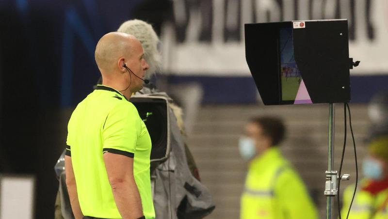 Schiedsrichter Szymon Marciniak aus Polen schaut sich den Videobeweis auf dem Monitor an.