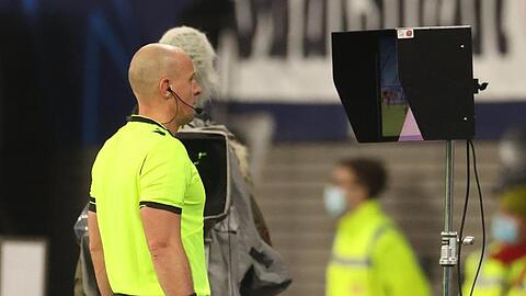 Schiedsrichter Szymon Marciniak aus Polen schaut sich den Videobeweis auf dem Monitor an.