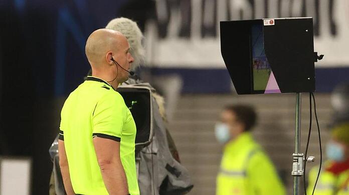 Schiedsrichter Szymon Marciniak aus Polen schaut sich den Videobeweis auf dem Monitor an.