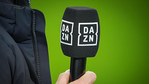 Chef-Trainer Kovac von Wolfsburg hält vor dem Spiel ein Mikrofon mit dem Logo des TV-Senders DAZN.