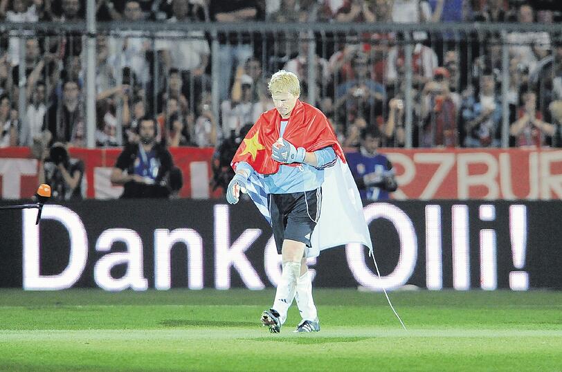 Das Ende einer großen Karriere: Oliver Kahn geht, eingehüllt von einer Bayern-Fahne, nach seinem Abschiedsspiel vom Platz.