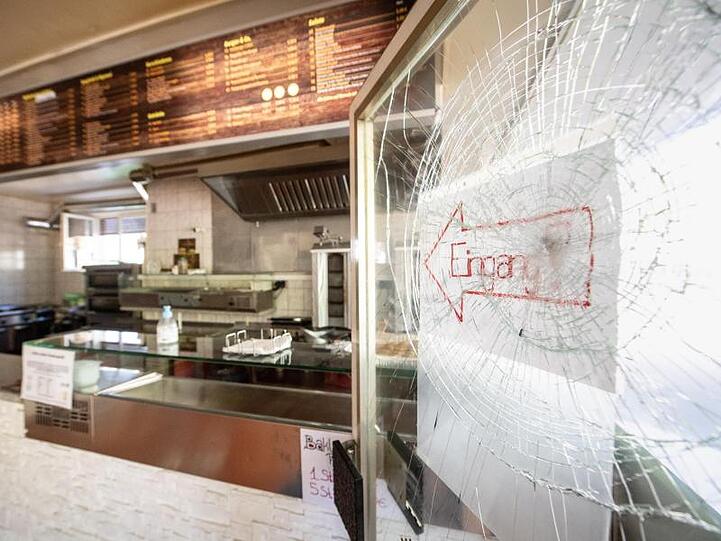 Ein Schild mit der Aufschrift "Eingang" klebt an einer zerbrochenen Scheibe eines türkischen Döner-Imbiss. Foto: Matthias Balk/dpa