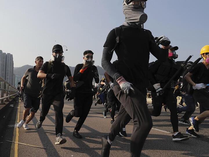 Schwarz gekleidete Demonstranten mit Schutzbrillen und Atemschutz: Trotz eines Verbots sind in Hongkong wieder Zehntausende für Demokratie und Menschenrechte auf der Straße.