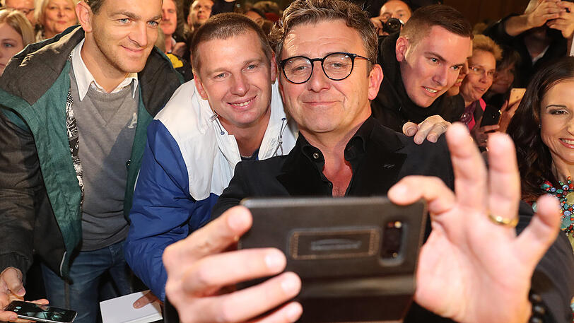 Schauspieler Hans Sigl macht Selfies.