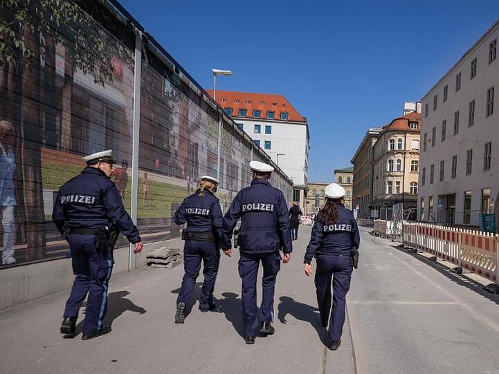 Polizisten patroullieren durch eine fast leere Straße. Foto: Peter Kneffel/dpa