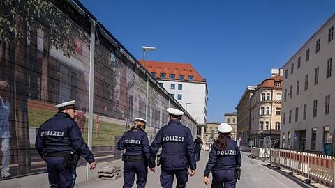 Polizisten patroullieren durch eine fast leere Straße. Foto: Peter Kneffel/dpa