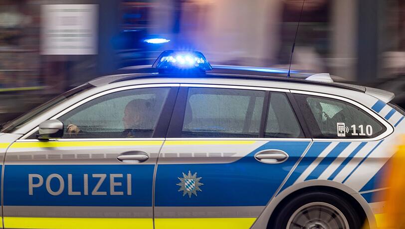 Ein Fahrzeug der bayerischen Polizei fährt mit Blaulicht durch die Münchner Innenstadt. (Symbolbild)