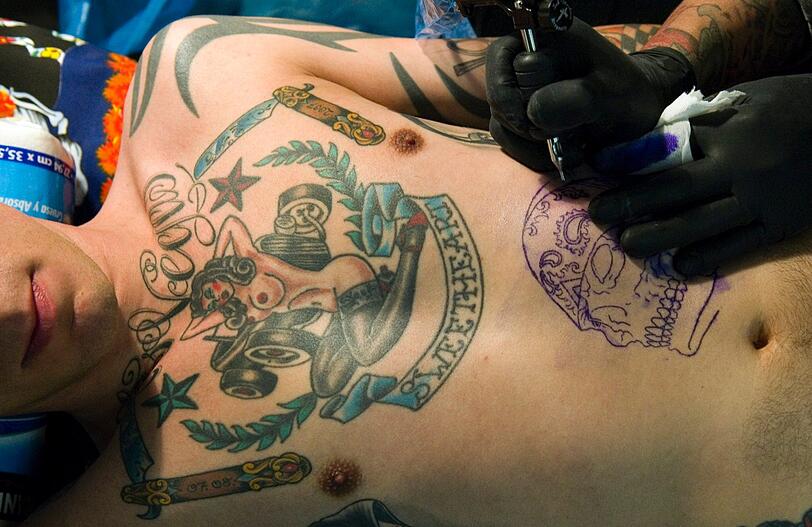 Auch dieser Mann arbeitet an einer Ganzkörperbemalung. Das Tattoo auf der Brust kann sich sehen lassen.