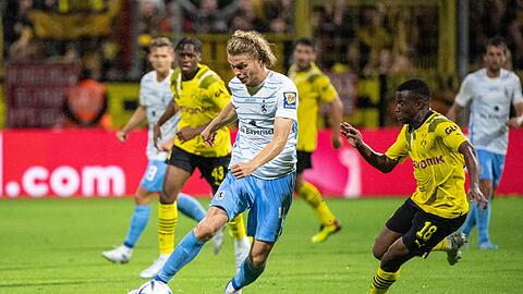 Jesper Verlaat von 1860 München (l) und Youssoufa Moukoko von Borussia Dortmund im Zweikampf um den Ball.