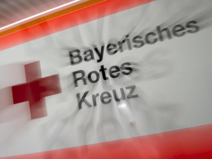 Das Logo des Bayerischen Roten Kreuzes ist an einem Rettungsfahrzeug zu sehen. Foto: Peter Kneffel/Archivbild