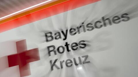 Das Logo des Bayerischen Roten Kreuzes ist an einem Rettungsfahrzeug zu sehen. Foto: Peter Kneffel/Archivbild