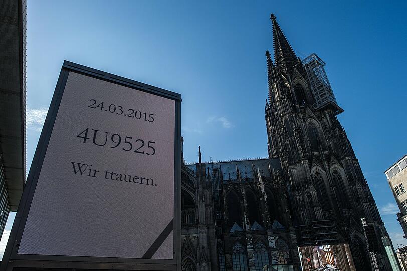 Eine Dispotafel mit der Aufschrift "4U9525 Wir trauern." erinnert in Köln vor dem Dom an die Opfer des Absturzes.
