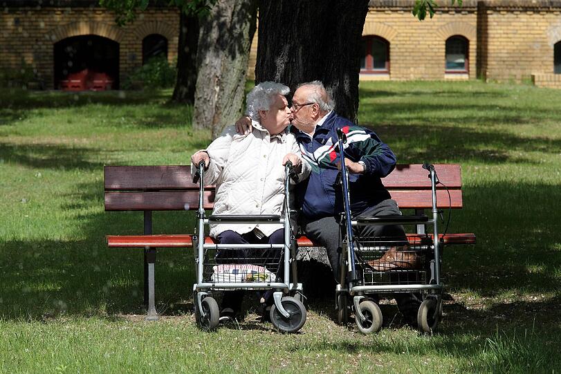 Haben gut küssen: Zwei Rentner genießen den Sommer ganz romantisch allein auf einer Parkbank.